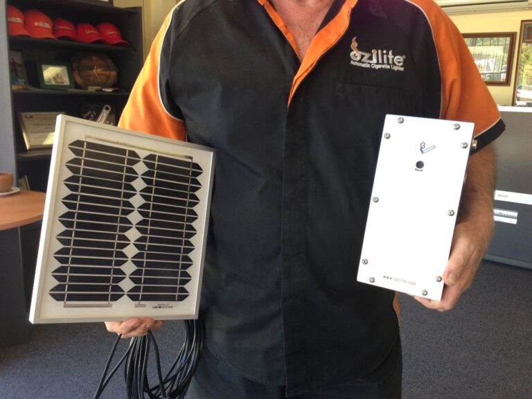 Person holding the compact Ozilite ACLBPS automatic cigarette lighter and solar panel