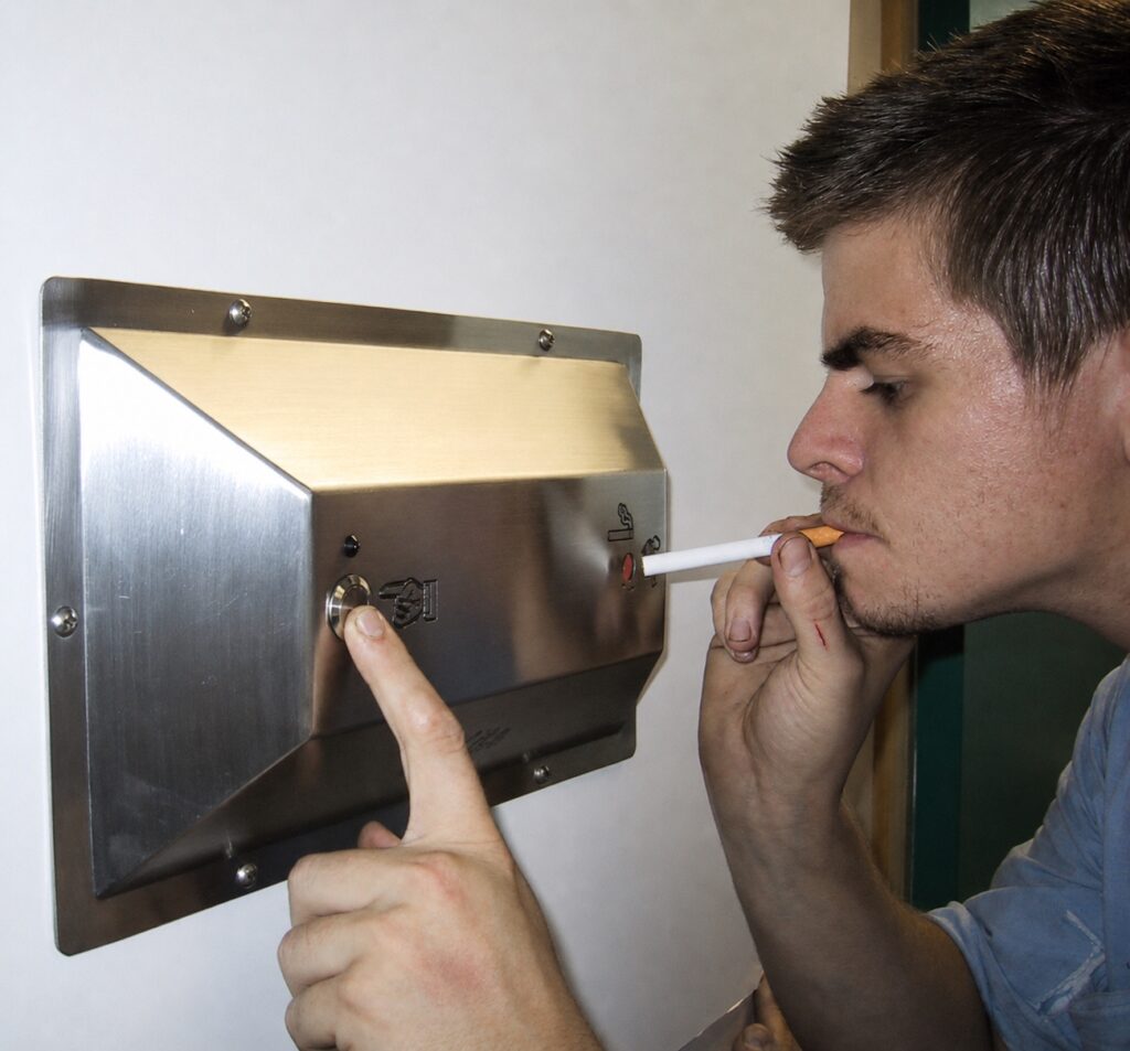 Person using an Ozilite ACL WMT wall-mounted flameless cigarette lighter