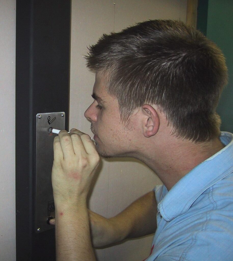 Person activating an Ozilite ACLST pole-mounted automatic cigarette lighter