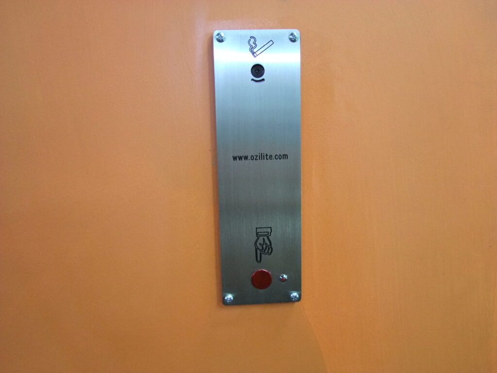 Ozilite ACLST vertical pole-mounted automatic cigarette lighter installed in an orange post